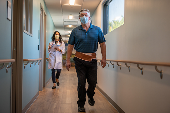 A man walking with researcher following