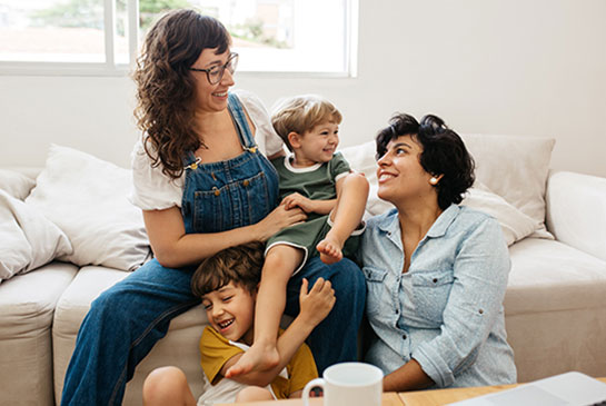 Happy LGBTQ+ family sitting together at home