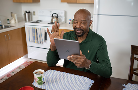 Woman sitting at home using a laptop for a telehealth video visit