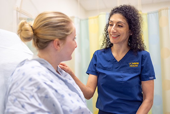 UC Davis doctor checking in on female patient in hospital room