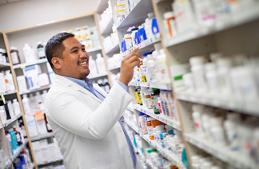Pharmacist selecting prescriptions from a shelf