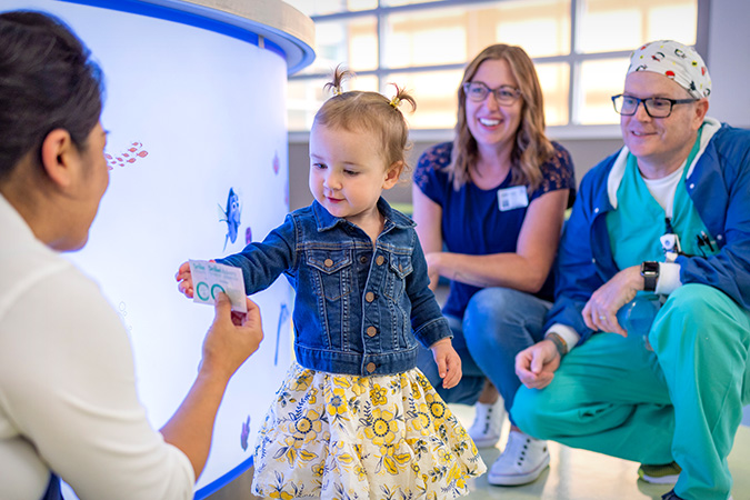 UC Davis doctors and team with young pediatric patient in hospital entry