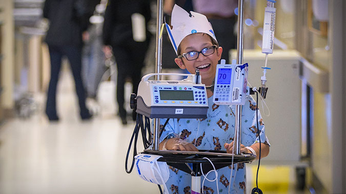 Patient walking down the hospital hall with cart
