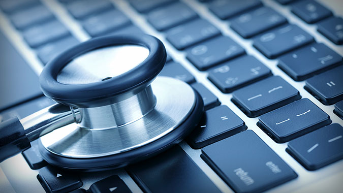 Stethoscope laying on computer keyboard.