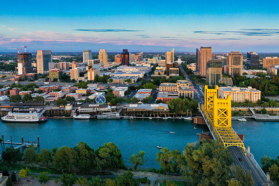 Downtown Sacramento, Sacramento River with large yellow bridge and large cruise boat, city skyline buildings