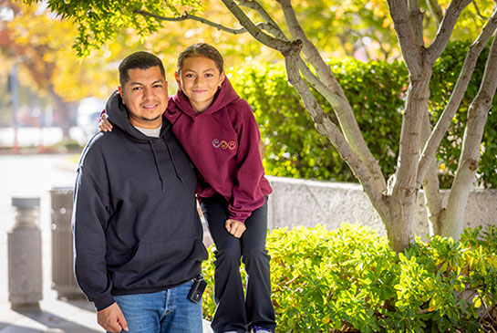 Erik Ramirez and daughter, Elena Martinez pose outside together.