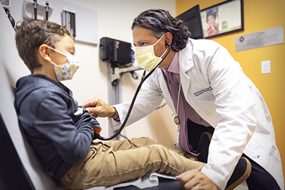 Pediatrician Fernandez y Garcia with young male patient in medical office setting