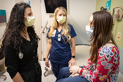 Pediatric patient with doctors in hospital room.