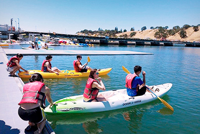 Students taking kayaks out on water