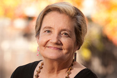 Randi Hagerman, wearing black shirt and earings portrait with blurred background