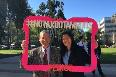 Doctor and resident pose in giant frame used for presentation to legislature.