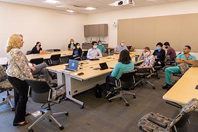 Residents meet in conference room around rectangular table configuration.
