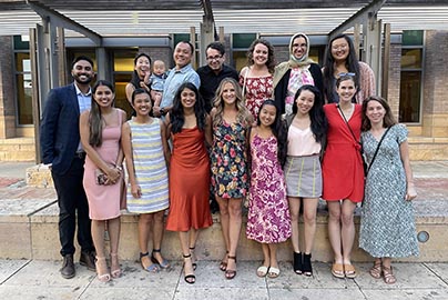 Residents pose for photo outside on orientation day. Sixteen residents and one baby.