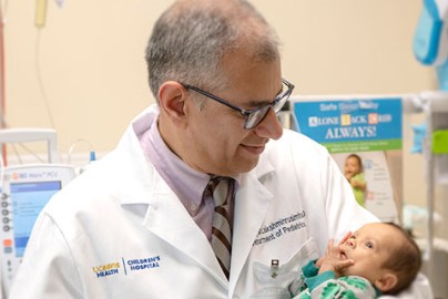 Doctor hold infant in PICU.