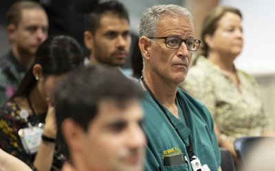 Grand Rounds seminar with doctors seated in rows.