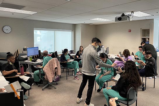 Presenter shows images on projection screen while residents watch and listen.