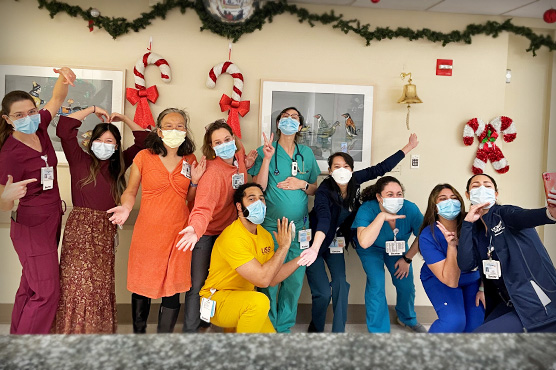 Residents pose for photos close to winter holiday with decorations in background.