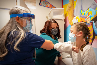 Two doctor elbow shake with young female patient
