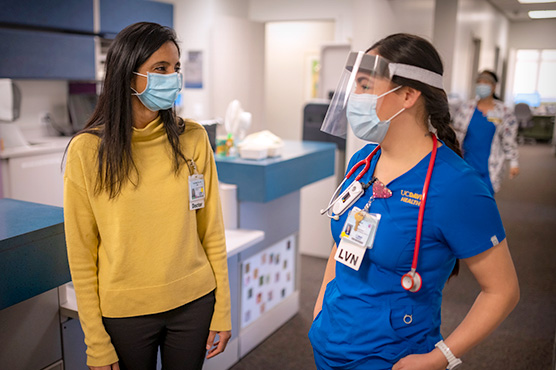 Dr. Hassan talking with nurse in hospital hallway