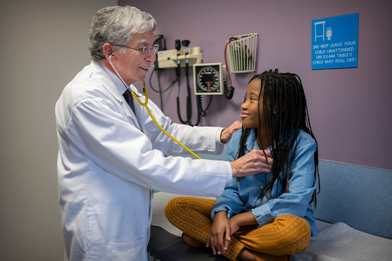 Dr. Stine, an endocrinologist at UC Davis, performing check-up of pediatric diabetes patient in clinic room