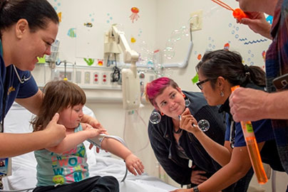 Doctors and nurses examine child female patient in emergency room setting