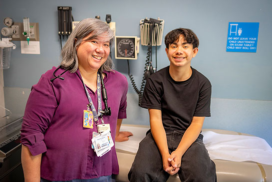 Dr. Nguyen and patient Justin Ramirez pose in exam room