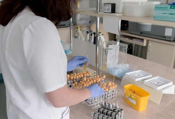 Researcher holding basket of vials
