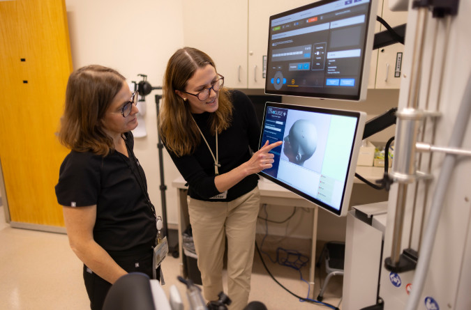 Two care providers looking at a monitor.