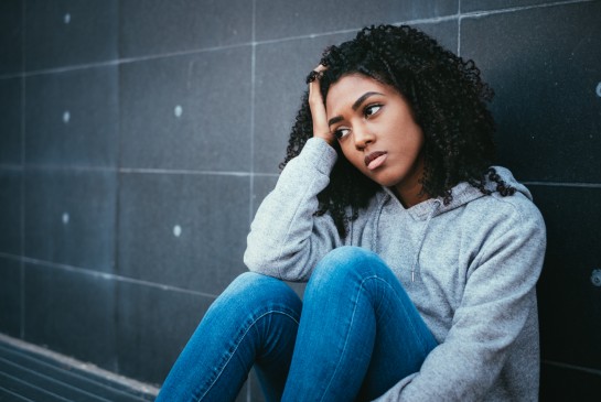 A girl sits and looks into the distance