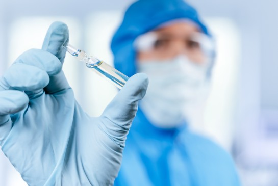A researcher holds a glass vial