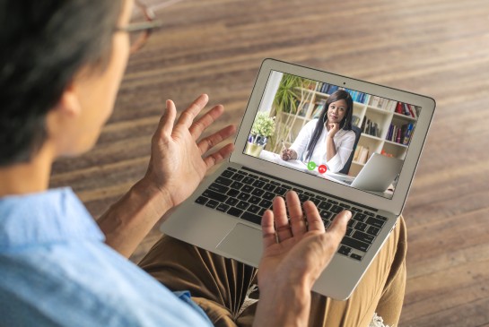 A physician speaks to a patient virtually via tablet 