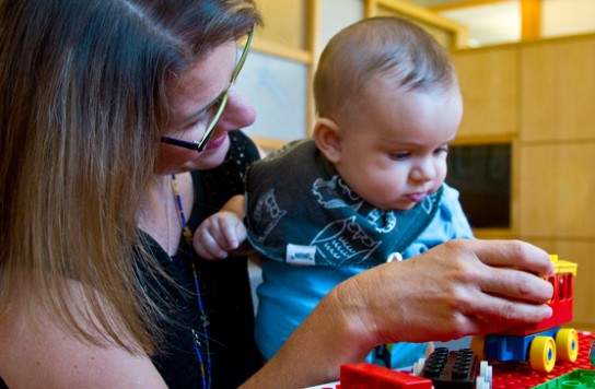 A woman playing with a baby