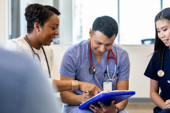 Practitioners smiling and viewing a clipboard