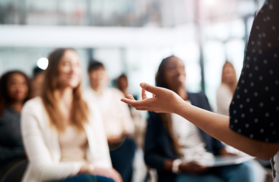 A woman lecturing in front of an audience