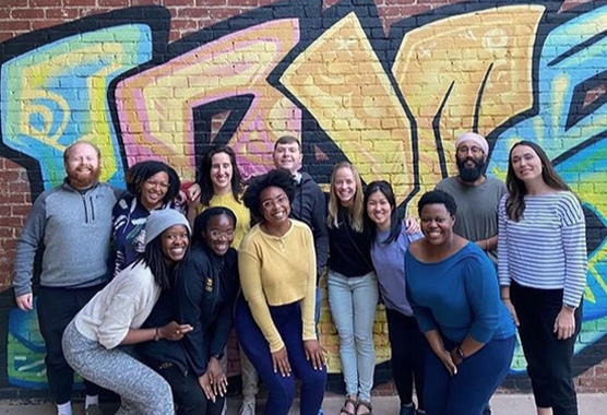 Residents group photo in front of graffiti wall in Sacramento