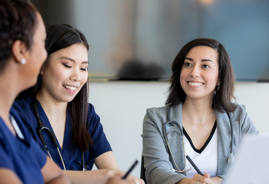 Three students smiling in conversation
