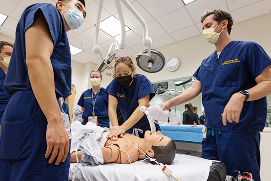 Doctors working on an infant mannequin.