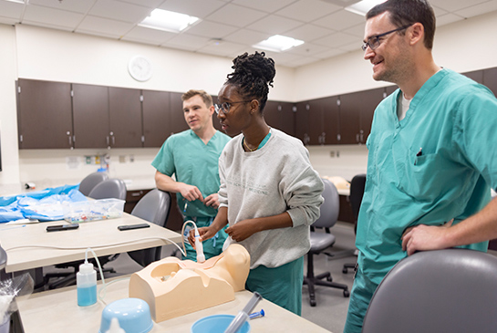 A student doctor working on a procedural training model.