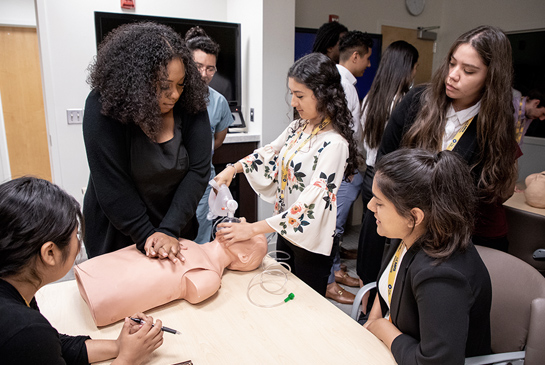 A student working on a suturing practice arm.