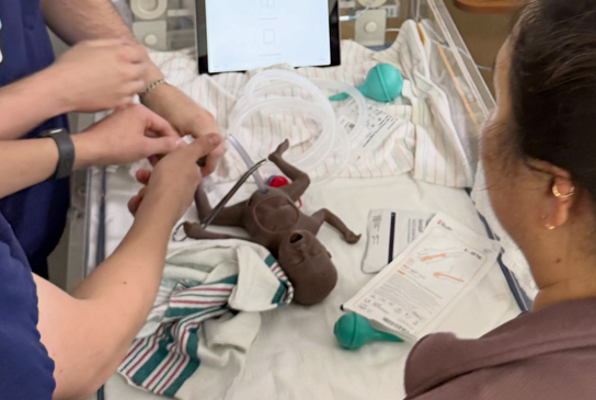 Physicians work on a pediatric simulation mannequin (c) UC Regents.