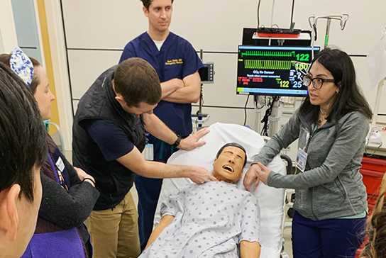 A group of healthcare workers around a simulated patient.