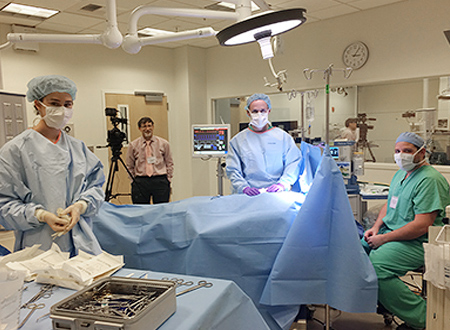 A group of surgeons and health care workers in a simulated surgery room.