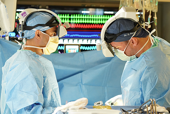 surgeons wearing augmented reality goggles while doing spine surgery