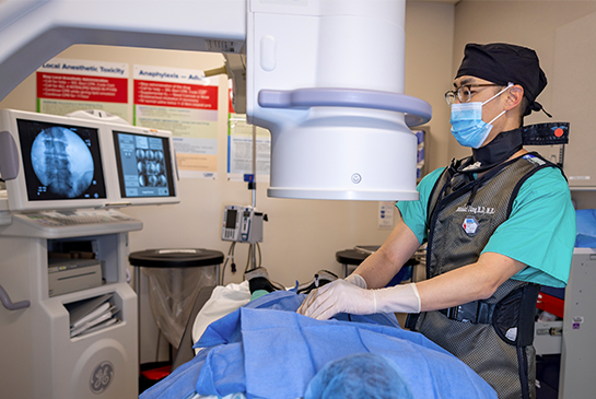 doctor using a peripheral nerve stimulator xray to review patient's spine