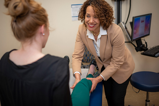 Doctor using technology to show an athlete issues in their anatomy.