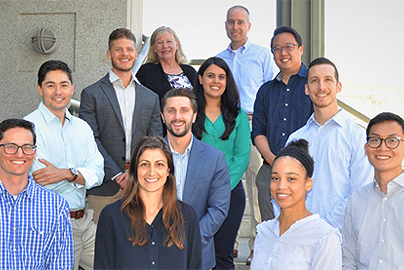 A group of UC Davis residence posing together on the steps of a building.