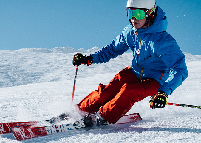 A man standing on the top of a mountain looking down into a valley.