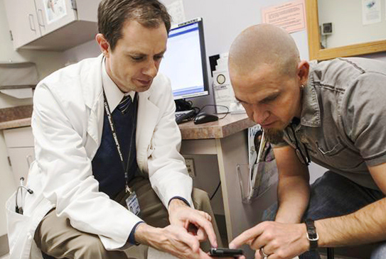 A man and woman sitting together and the man is coughing.