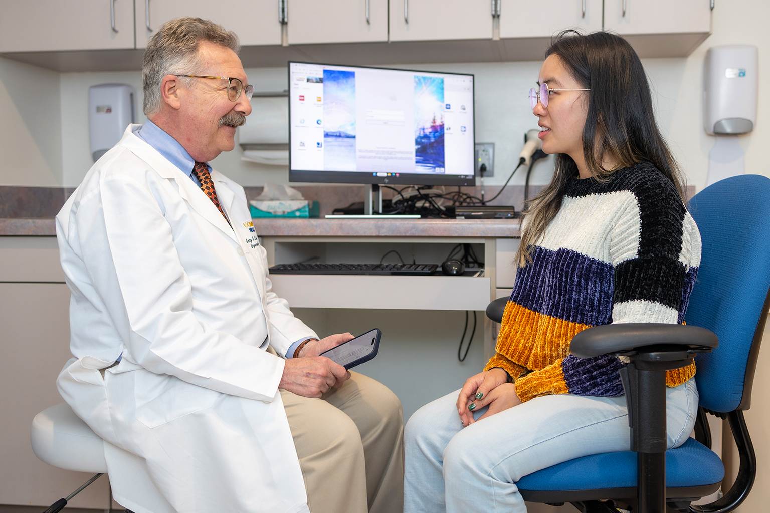 A doctor and patient in a warm, human-centered interaction aided by technology