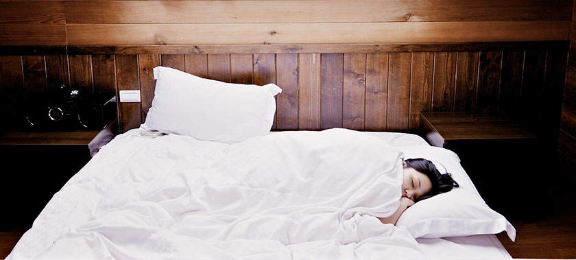 woman asleep in bed with overhead light